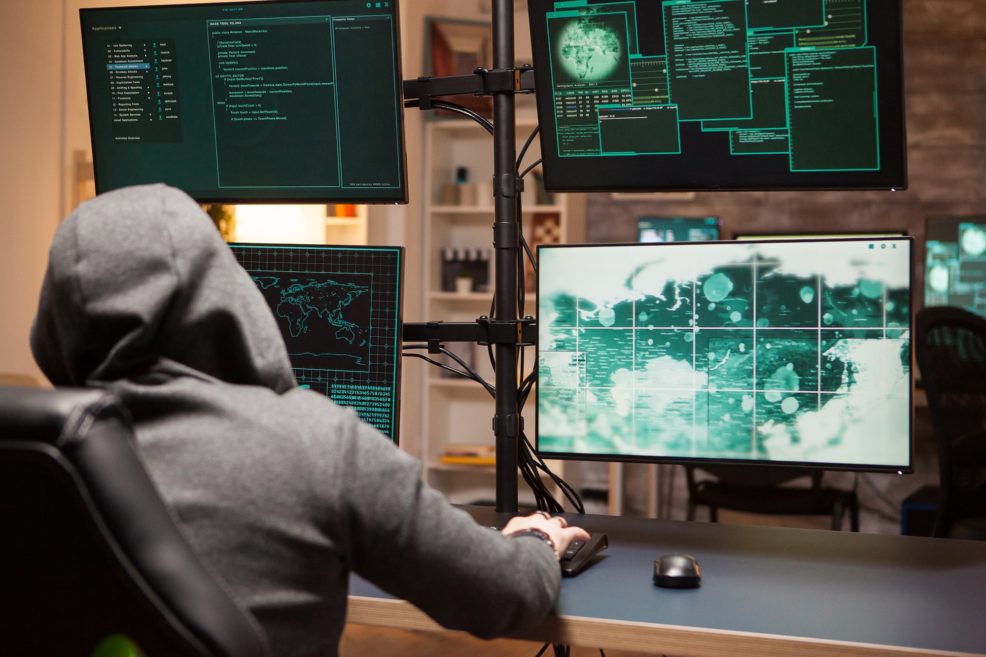 Cyber criminal wearing a hoodie writing a dangerous virus