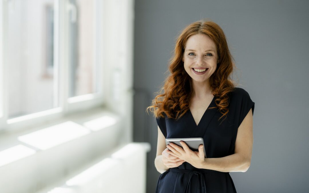 Portrait of content redheaded businesswoman with digital tablet in a loft