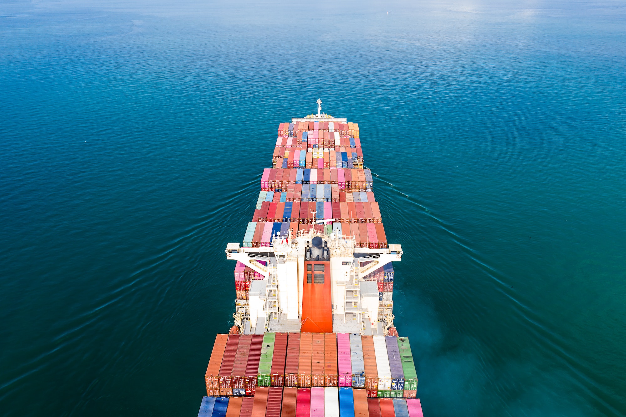 Aerial top view of cargo ship carrying container for import export goods to customer