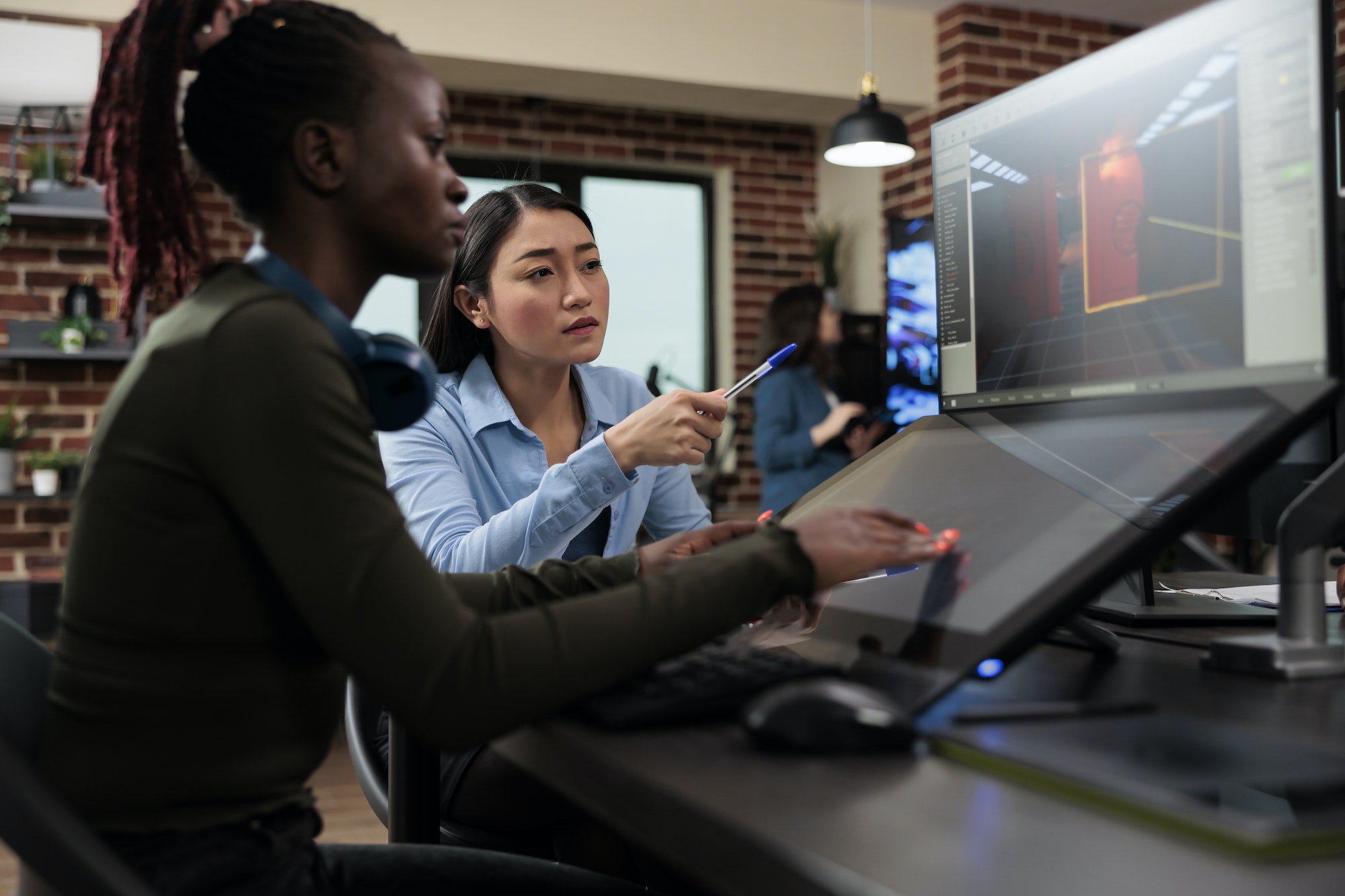 Production department 3D artist team leader with multiple displays on desk working on digital